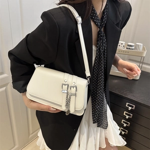 Petit sac rétro blanc porté à l'épaule avec chaîne argentée et sangles à boucles