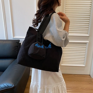 Black nylon tote bag with blue Beach embroidery and a small matching round pouch