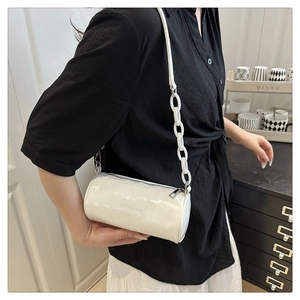 Détail du sac bandoulière cylindrique blanc avec grosse chaîne et finition brillante