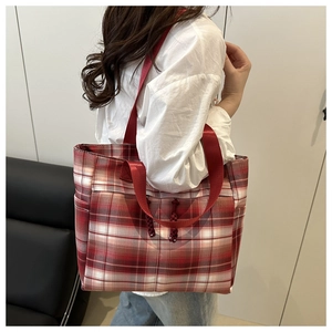 Detail view of large red and white checkered tote bag with a durable red woven shoulder strap