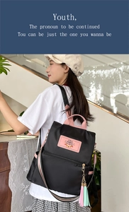 Close-up of black nylon backpack with pink handles and Rabbit logo patch details