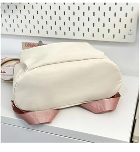 Detail view of the vintage backpack bottom in cream white with rose pink straps