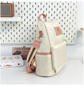 Detail of cream backpack with pink trim and stylish red-green striped shoulder straps