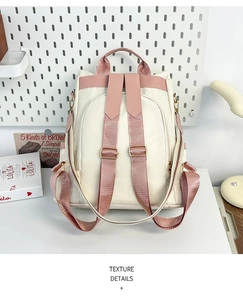 Detail of pink adjustable shoulder straps with golden metal buckles on a cream backpack