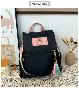 Détail du sac à dos en nylon noir avec accents roses et bandoulière tissée colorée