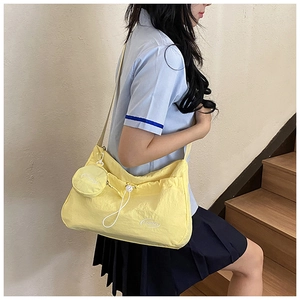 Detail of lemon yellow nylon crossbody bag with fashion print and round charm pouch