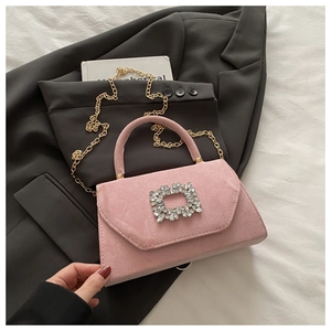Dettaglio borsa in camoscio rosa con fibbia in strass e tracolla a catena dorata