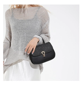 Détail d'un sac à main noir de luxe avec rabat en strass brillant et fermoir doré