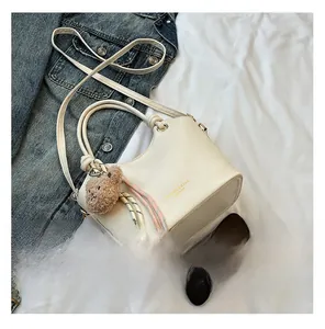 Detail view of cream bucket bag capacity with a smartphone for size reference