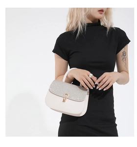 Détail du sac à main blanc élégant avec rabat pailleté et fermoir doré chic