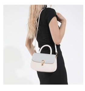 Détail du sac bandoulière rose avec paillettes argentées et fermoir doré sur le modèle