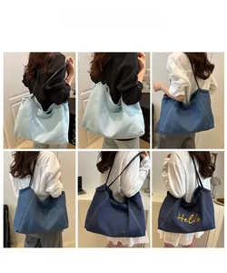Detail view of denim shoulder bags with Hello embroidery in three shades of blue