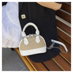 Detail of woven straw and white leather shell bag with silver chain and dual handles