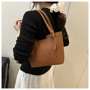 Detailed view of brown litchi pattern leather tote bag with elegant metal ring buckle