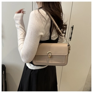 Détail du sac à main beige avec texture cuir galet et boucle en métal doré élégant