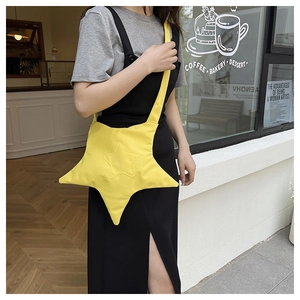 Style de rue d'un sac bandoulière en nylon jaune vif en forme d'étoile porté par un modèle