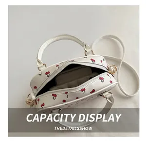 Internal capacity of cherry print shell bag holding a phone and a wallet