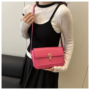 Close-up of rose pink crossbody bag with litchi grain and gold teardrop clasp detail