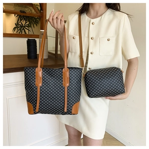 Detail of grid pattern tote bag set with brown leather straps in a cafe setting