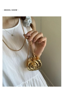 Exquisite gold rose-shaped clutch bag with delicate snake chain shown on a model