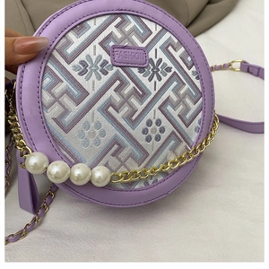 Detail der runden lila Tasche mit Blumenstickerei und Perlen-Schulterriemen