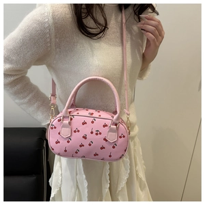 Detail of pink strawberry print shoulder bag with gold metal buckle and top handle