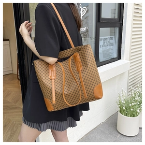 Détail d'un grand sac cabas avec motif classique et finitions en cuir orange à la base