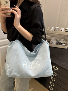 Grand sac cabas en jean bleu avec broderie Hello blanche et fines anses noires