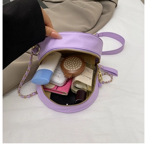 Detailansicht einer lila runden Umhängetasche mit Platz für Make-up und eine Powerbank