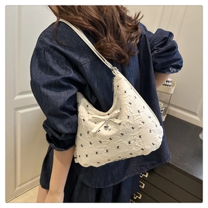 Détail du sac à bandoulière blanc plissé avec motif lapin et pendentif cœur