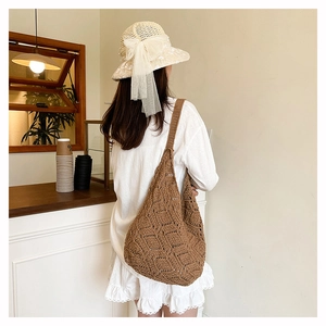 Vue détaillée d'un sac cabas en paille crocheté à la main marron avec motif losange