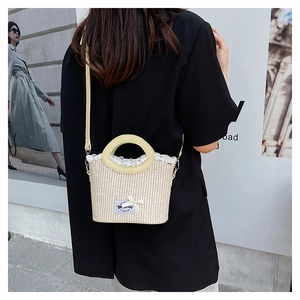 Détail du sac en paille tissé à la main avec dentelle délicate et bandoulière en cuir