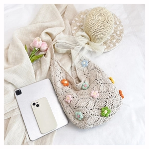 Détail d'un sac cabas en crochet fait main avec broderies de fleurs colorées et texture tissée