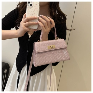 Detailed shot of pink glitter handbag with golden twist lock and slim shoulder strap