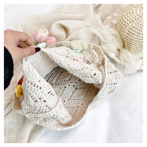 Détail du sac crocheté main crème avec fleurs en tricot 3D colorées et texture détaillée