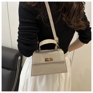 Detailed view of silver sequin crossbody bag with gold twist lock and adjustable strap