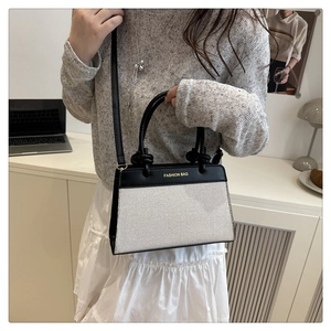 Detail of vintage canvas and leather contrast handbag shown on model for size and fit