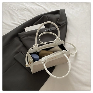 Detail showing inner storage of minimalist beige canvas bag with knotted handle strap