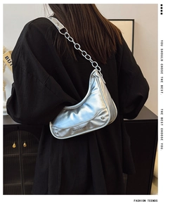 Détail du sac demi-lune argenté avec chaîne en métal et texture en similicuir