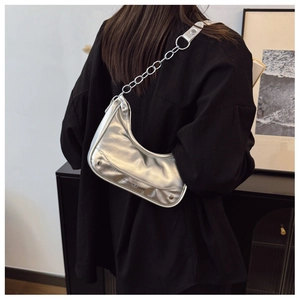 Detail of silver metallic hobo bag with chain strap and printed fashion logo