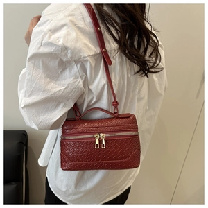 Close-up of deep red woven texture and golden metal hardware on the retro box bag
