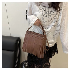 Dettaglio della borsa boho marrone con rivetti argentati e lunghe nappe a frangia