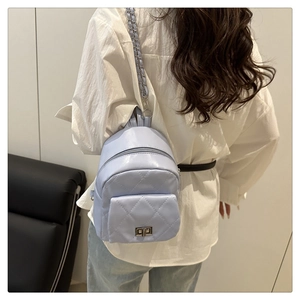 Detail of light blue quilted mini backpack with rhombic pattern and silver metal lock