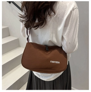 Brown canvas shoulder bag with FANYISSA logo shown on a model in a minimalist setting