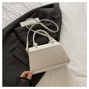 Flat lay of woven handbag with white leather trim and Fashion Bag text on stylish blazer