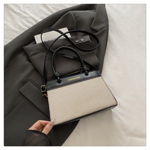 Detail view of the black and white canvas tote bag with FASHION BAG text and leather handle