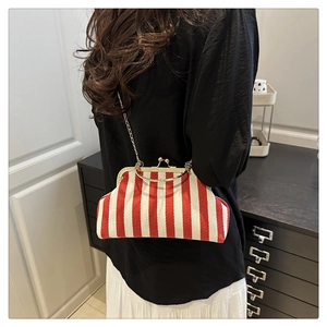 Détail du sac à clip vintage à rayures rouges et blanches avec poignée dorée et chaîne