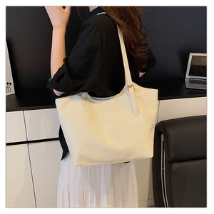 Detail of minimalist beige faux leather tote bag with smooth texture and long shoulder straps