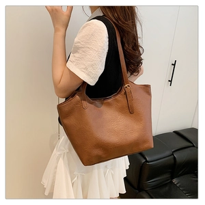 Close-up of brown faux leather tote bag showing retro texture and adjustable shoulder strap