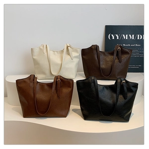 Four vintage tote bags in white, coffee, tan, and black displayed on geometric stands